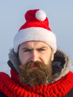 Sakallı Noel Baba. Blue Sky 'da yeni yıl çocuğu. Yüzünde uzun sakallı ve bıyıklı Noel adamı. Xmas partisi kutlaması. Kırmızı şapkalı ve eşarplı Noel Baba hipster