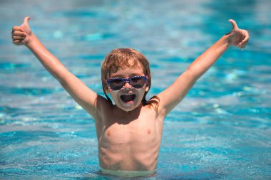 Çocuk yüzme havuzunda yüzüyor. Havuzdaki aktiviteler, yüzen ve oynayan çocuklar, mutluluk çocukları ve yaz zamanı.