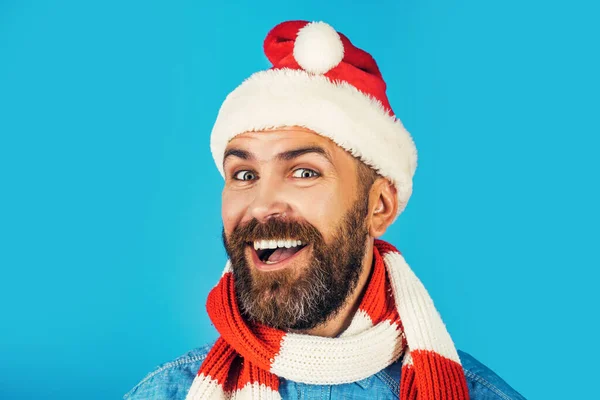 Kerstman blij glimlachen in santa hoed en sjaal op blauwe achtergrond. Nieuwjaar, Kerstmis, Wintervakantie viering, kopieerruimte. Gebaarde kerstman — Stockfoto