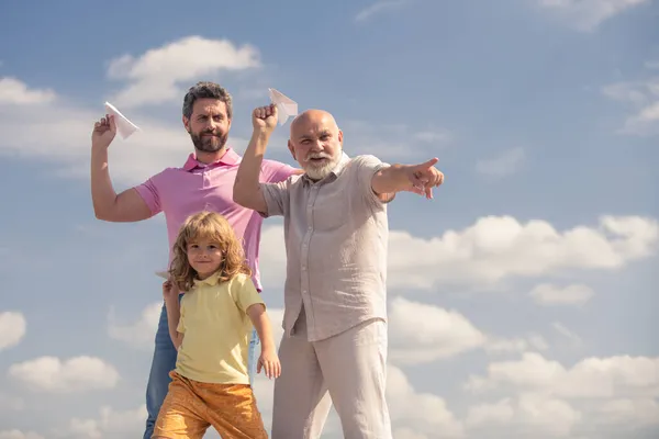 Männergeneration: Großvater Vater und Enkel spielen mit Spielzeugflugzeug im Freien am Himmel. Junge träumt davon, Pilot zu werden. Familienabenteuer, Fantasie, Innovation und Inspiration. — Stockfoto