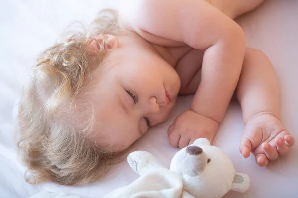 Barnet sover i sängen hemma med leksak, barnet sover i sängen. Barnet sover med leksaker. Barnen är sömniga. Bedårande små barn vila sova njuta av god hälsosam lugn sömn eller tupplur. — Stockfoto