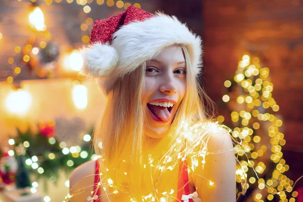Krásná mladá žena v Santa Claus oblečení přes Vánoce zdobené interiéru pozadí. Detail portrét sexy dívka flirtování na kameru. — Stock fotografie