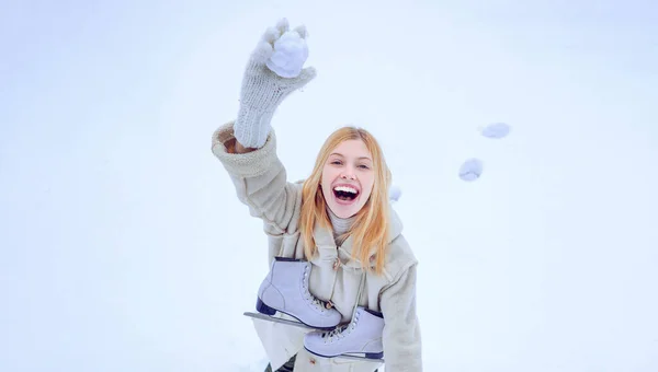 Drôle de jeune femme souriante en plein air en hiver. Joyeux hiver femme amusante. Jeu d'hiver. Belle jeune femme souriante en vêtements chauds avec patins à glace. — Photo