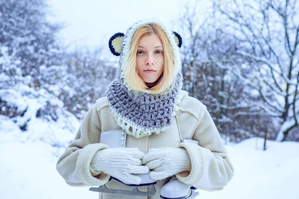 Donna invernale. Giovane donna bionda in maglione e cappello divertente con pattini bianchi sulle spalle nella gelida giornata invernale. Vacanza invernale. — Foto Stock