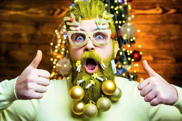 Fashion portret van knappe man binnen met kerstboom. Nieuwjaarsconcept. Sexy kerstman poseren op vintage houten backgroun — Stockfoto