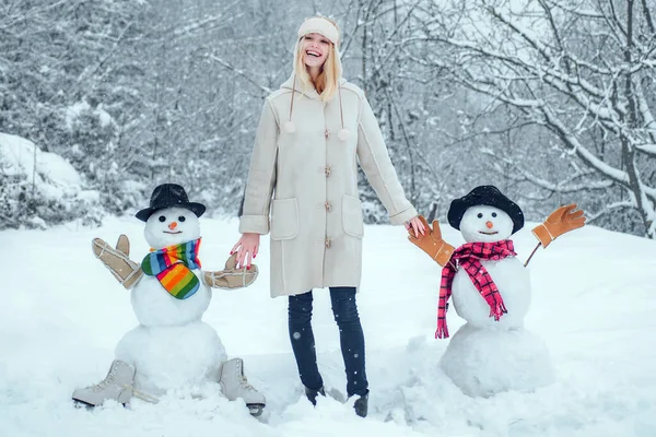 Téli nő. Vicces lány szerelem tél. Téli portré fiatal nőről a téli havas tájban. Aranyos lány, hogy hóember a havas pályán szabadban. — Stock Fotó