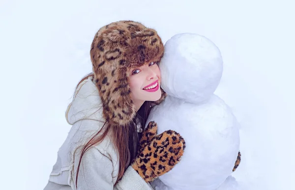 Zimowa kobieta. Zimowa dziewczyna robi bałwana. Szczęśliwa dziewczyna bawiąca się bałwanem na śnieżnym zimowym spacerze. Zimowe emocje. Młoda kobieta zimowy portret. — Zdjęcie stockowe