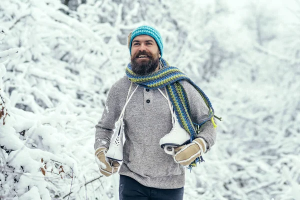 Muž s bruslemi v zasněženém lese. Muž v termálním saku, v zimě teplý vous. Zimní sport a odpočinek, Vánoce. Vousatý pohledný muž, Santa Claus — Stock fotografie