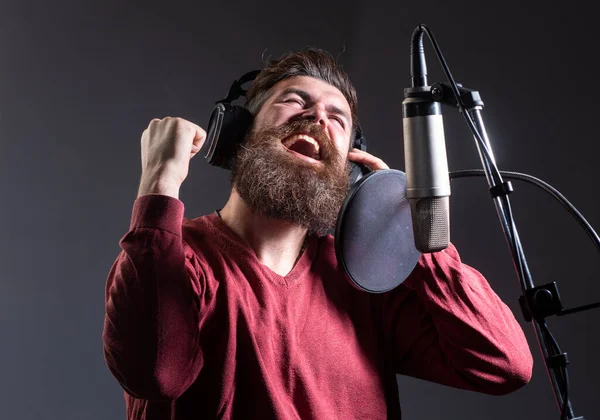 Śpiewak śpiewający rock. Wyraz twarzy z bliska. Producent dźwięku nagrywający piosenkę w studiu muzycznym. Podekscytowany karaoke. — Zdjęcie stockowe
