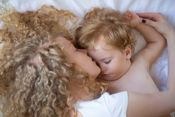 Giovane madre e bambino vanno a letto insieme. Sogni e bambini dormono. — Foto Stock