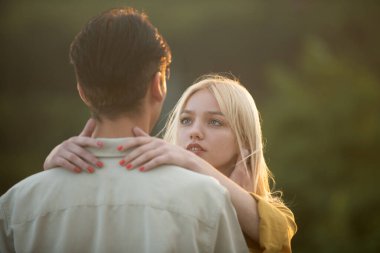 Gün batımında sarılıp öpüşen aşıklar. Genç aşık bir çift birlikte zaman geçirir. Erkeğin kucaklaması ve şehvetli bir kadını öpmesi.