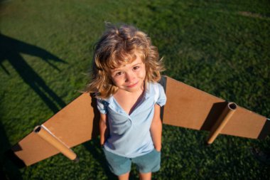 Oyuncak jetpack ile oynayan komik çocuk. Çocuk pilot astronot ya da uzay adamı uçmayı hayal eder. Karton kanatlarla uçan havacı çocuk..