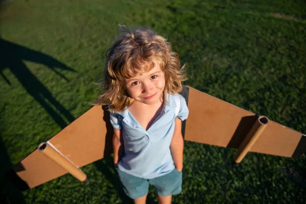 Oyuncak jetpack ile oynayan komik çocuk. Çocuk pilot astronot ya da uzay adamı uçmayı hayal eder. Karton kanatlarla uçan havacı çocuk..