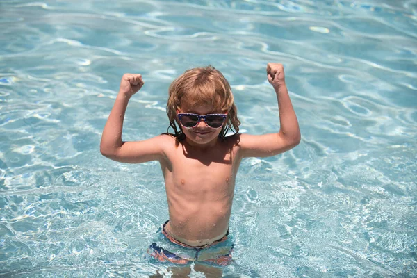 Niño en la piscina. Emocionado lindo niño en gafas de sol en la piscina en el día soleado. — Foto de Stock