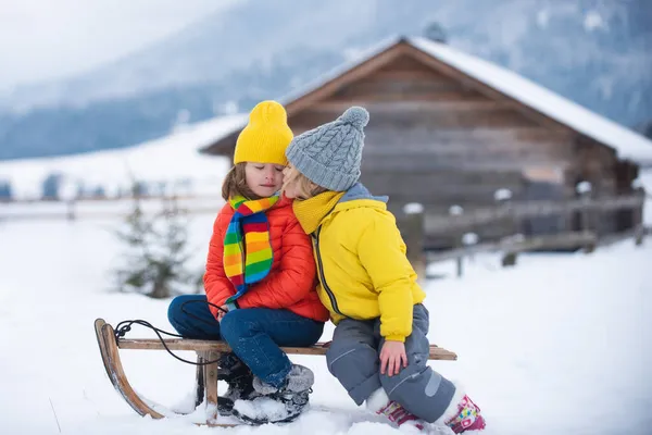 Діти цілуються. Милі діти хлопчик і дівчинка поцілувалися на зимовій прогулянці на природі. Зимовий в'язаний дитячий одяг. Холодна погода. Щасливі маленькі діти в трикотажному капелюсі, шарфі і светрі . — стокове фото