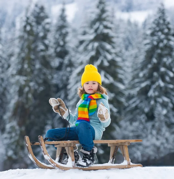 Drôle de garçon s'amuser, jouer avec la boule de neige avec un traîneau en hiver. Enfants mignons jouant dans une neige sur un paysage naturel enneigé. Activités hivernales pour les enfants. — Photo