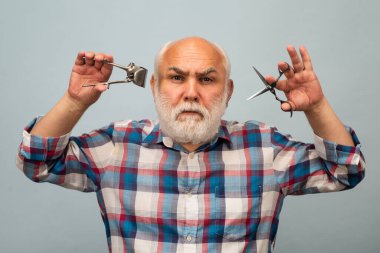 Berber makası ve saç makasıyla orta yaşlı berber. Klasik berber, tıraş..