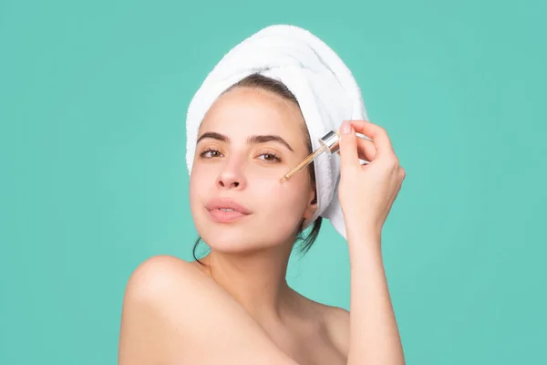 Atractiva señora hidratante cara con aceite. Hermosa chica con una toalla en la cabeza, tratamiento facial, cosmetología, belleza y spa. — Foto de Stock