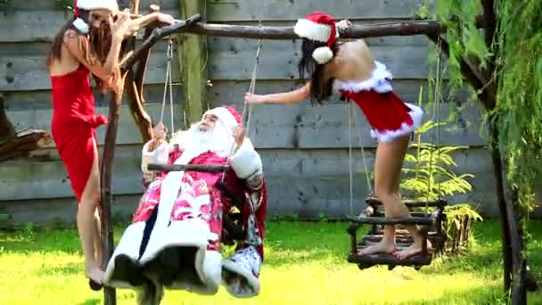 Funny crazy santa swinging with sexy santa girls snow maiden. Christmas party concept. Santa senior man with sexy woman. — Stock Video