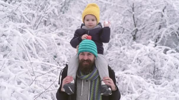 Invierno padre e hijo paseo a caballo al aire libre en el bosque de nieve. Papá jugar con niño bola de nieve lucha. — Vídeos de Stock