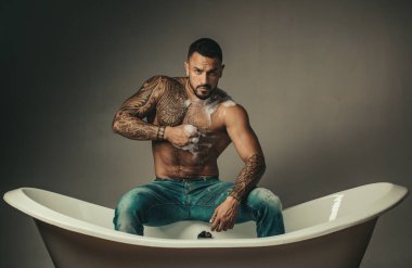 Küvette yıkanan çıplak vücutlu seksi adam..