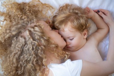 Küçük anne ve bebek birlikte yatıyorlar. Tatlı rüyalar ve çocuklar.