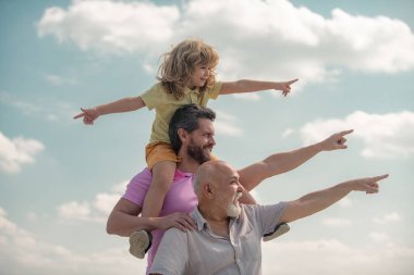 Baba ve oğul büyükbabayı işaret ettiği için çok heyecanlıydılar. El işaretleri noktası. Üç nesildir erkekler dışarıda eğleniyorlar..