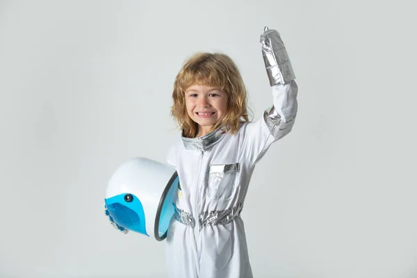 宇宙服のヘルメットと金属のスーツを持つ宇宙飛行士になるために遊んで素晴らしい男の子. — ストック写真