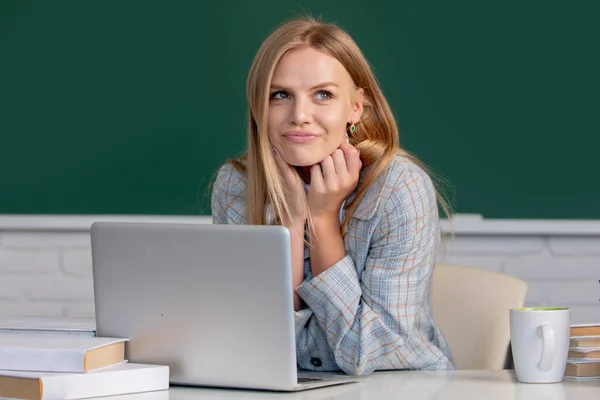 Vrouwelijke student op les college in de klas op de middelbare school of universiteit. Creatieve jonge glimlachende vrouwelijke student met behulp van laptop. — Stockfoto