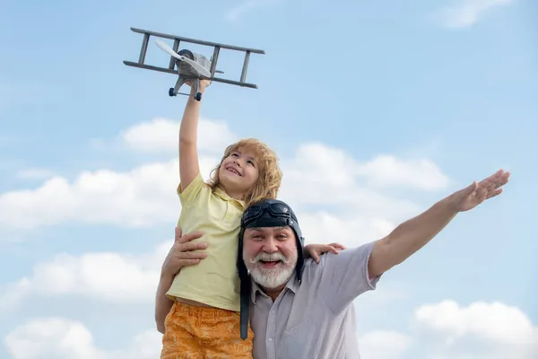 아이들 과 할아버지가 장난감 비행기를 가지고 놀고 있습니다. 여름 하늘을 배경으로 해서 요. 주말에 할아버지와 함께. — 스톡 사진