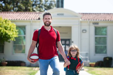 Amerikan baba ve oğlu okul parkında yürüyor. Ebeveyn çocuğu okula götürür. İlkokul öğrencisi dışarıda sırt çantasıyla ders çalışmaya gitti. Baba ve çocuk el ele gidiyor. Dersler başlıyor..