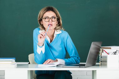 Modern çekici öğretmen. Lisede ya da kolajda tahtaya kitap yapıştırılmış, gözlüklü zeki genç bir kadının portresi. Üniversitede kız öğrenci eğitimi. Eğitim, okul ve insanlar.
