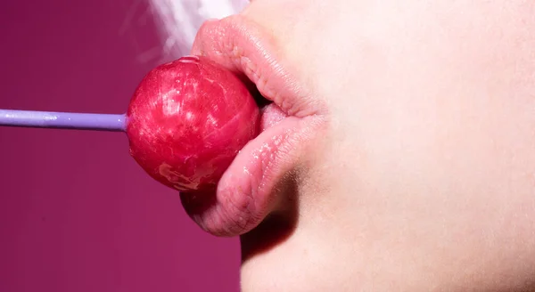 赤い唇でおいしいロリポップを舐めるグラマー口。ロリポップを吸う。セクシーな女性の唇。官能的な女性はロリポップと赤い唇。キャンディーバーのコンセプト. — ストック写真