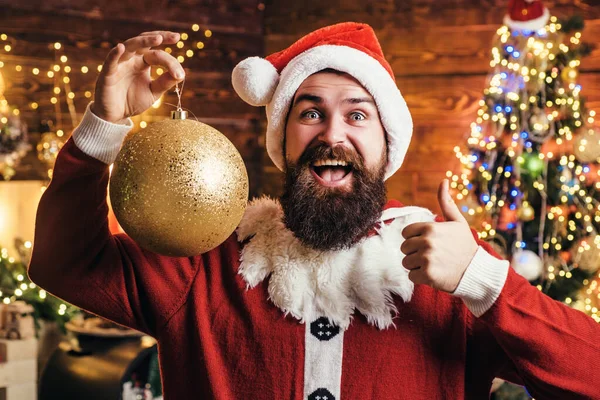 Verrückter, lustiger Hipster Santa. Porträt eines glücklichen Weihnachtsmannes mit dekorativen Spielzeugkugeln in der Nähe des Weihnachtsbaums. Weihnachtsmann an Weihnachten. — Stockfoto