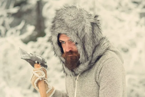 Homme bûcheron avec hache. Homme barbu avec hache dans une forêt enneigée. Gros plan sur le visage en colère. — Photo