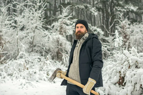 Homem lenhador com machado ao ar livre no inverno. Homem barbudo com machado na floresta nevada. — Fotografia de Stock