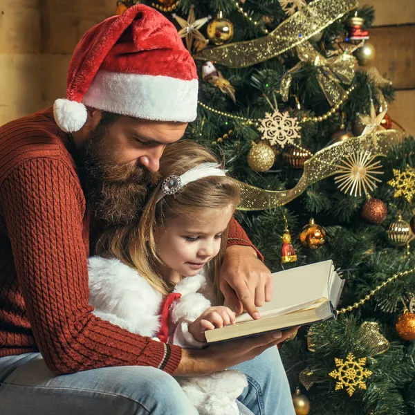 Natale Babbo Natale padre e figlia leggere libro. Vacanza invernale in famiglia a casa — Foto Stock