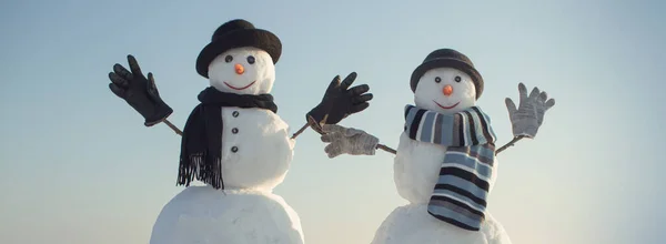 Couple bonhomme de neige avec chapeau et écharpe en hiver en plein air. Nouvel an bonhommes de neige de neige dans le chapeau de Père Noël. — Photo