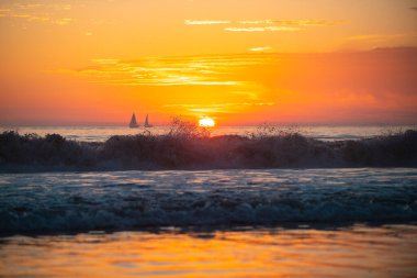 Denizin üzerinde deniz manzaralı altın gün doğumu. Doğa manzarası. Okyanus batımında güzel turuncu ve sarı renk. Altın gökyüzü ve bulutlu deniz manzarası.