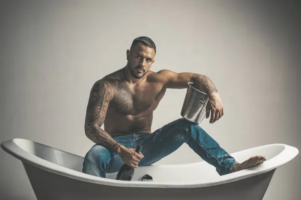 Sexy homme déshabillé séduisant assis sur la baignoire dans la salle de bain, les hommes vacances avec du champagne. Partie de sexe privé. — Photo