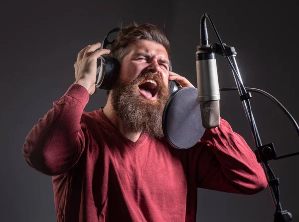 Sänger in einem Tonstudio. Ausdrucksstarker bärtiger Mann mit Mikrofon. Ausdruck aus nächster Nähe. Karaoke-Unterzeichner, Sänger. — Stockfoto