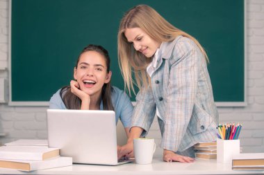 Kolejdeki kız öğrenciler. İki öğrenci ödev yapıyor ve birbirlerine yardım ediyorlar..