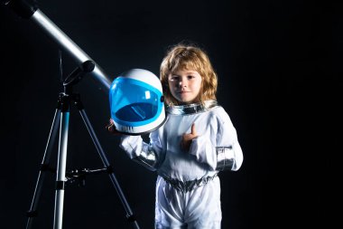 Teleskoplu çocuk astronot kostümü giyiyor. Astronomi ve astroloji kavramı.