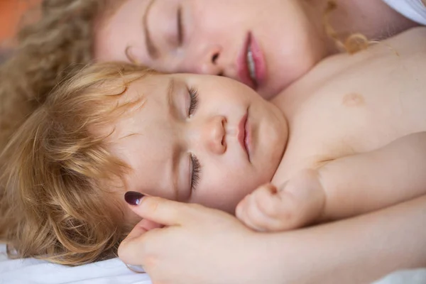 Мать и ребенок спят в кровати. Семейное утро в спальне. Крупные планы. — стоковое фото