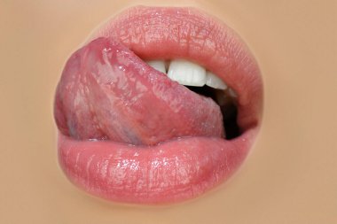 Güzel ağız ifadesi konsepti. Dudaklarını şehvetli bir dille yalayan kırmızı rujlu bir kadın yüzü..