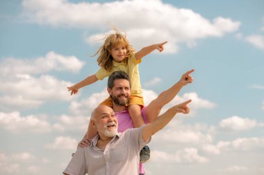 Baba ve oğul büyükbabayı işaret ettiği için çok heyecanlıydılar. El işaretleri noktası. Mutlu jenerasyon dilsiz üç nesil erkek aile portresi.
