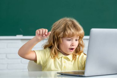 Okul çocuğu sınıfta dijital bilgisayar kullanıyor. İlkokul öğrenim programının komik öğrencisinin portresi. Çevrimiçi öğrenme teknolojisi, sanal eğitim webinar.