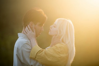 Şehvetli aşıklar gün batımında sarılıp öpüşüyorlar. Birbirine aşık, şehvetli aşıklar kucaklaşıp sarılıyorlar..