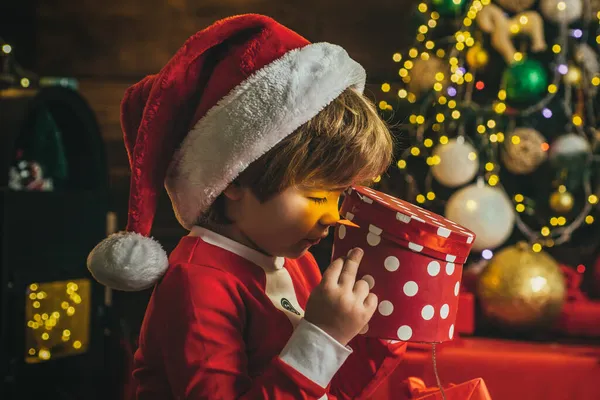 Menino surpreso criança abrir presente de Natal perto da árvore de Natal. Bebê adorável desfrutar de Natal. Engraçado crianças rosto closeup. — Fotografia de Stock
