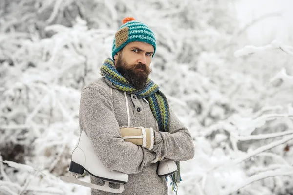 Zimní muž. Vánoce. Vousatý muž s bruslemi ve zasněženém lese — Stock fotografie